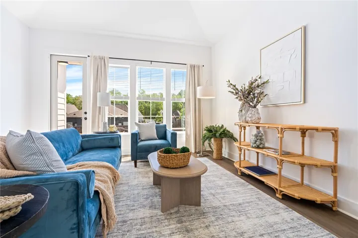 Spacious living area with vaulted ceiling and large windows over looking the backyard.