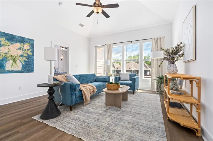 Spacious living area with vaulted ceiling and large windows over looking the backyard.