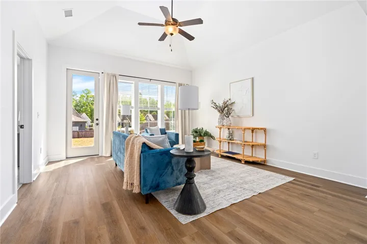 Spacious living area with vaulted ceiling and large windows over looking the backyard.