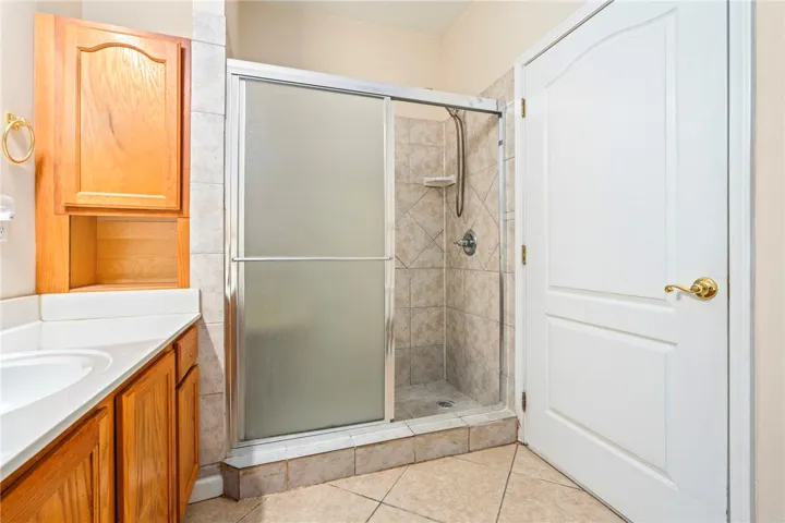 En suite Master bath offers glass-enclosed shower with tiled walls and flooring.