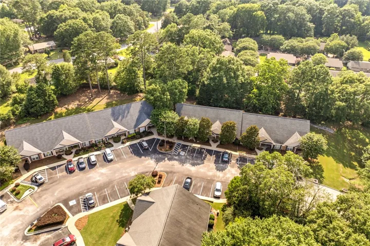 An aerial perspective reveals a charming condo comple nestled amidst abundant, mature trees.