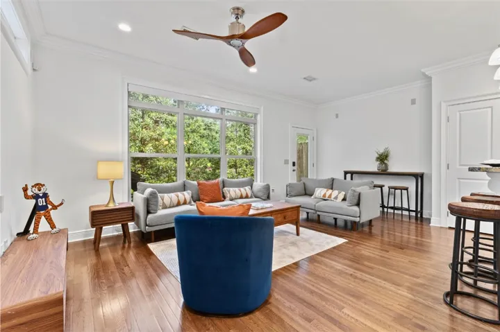 This bright living space features rich wood flooring and large windows, creating an inviting atmosphere.