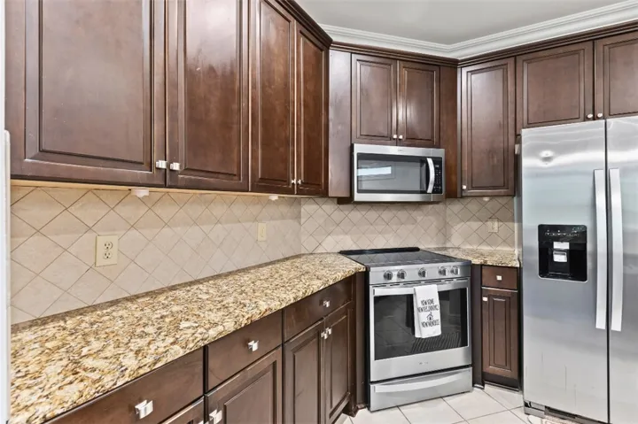 This culinary space boasts rich cabinetry and stainless steel appliances, offering both style and functionality.