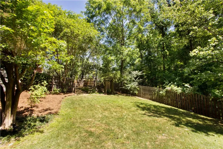 This spacious yard offers a serene retreat surrounded by lush greenery and natural privacy.