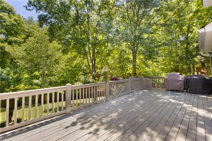 Enjoy outdoor living on this expansive deck, surrounded by verdant trees and lush greenery.