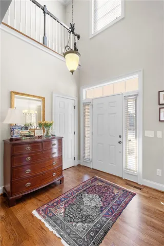 Step inside this inviting home featuring a grand entry with high ceilings and rich hardwood flooring.