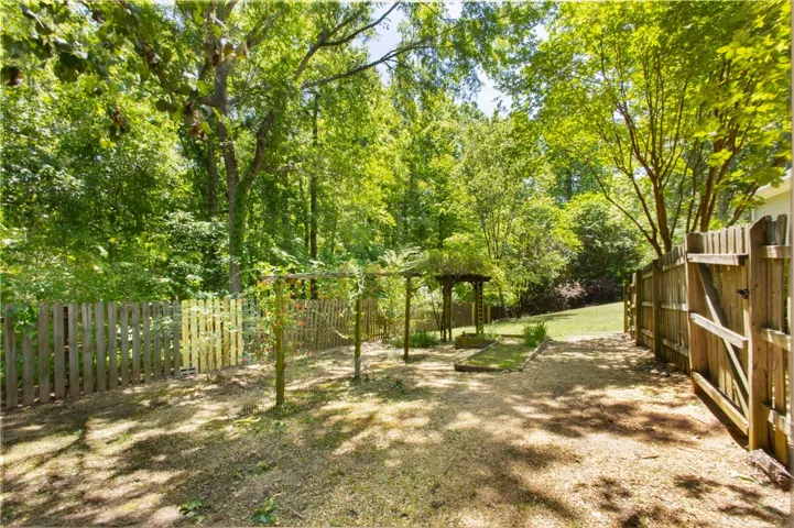 This serene backyard retreat offers a private oasis surrounded by lush greenery and a charming gazebo.