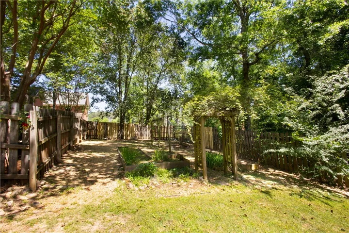 This verdant outdoor space offers a charming pergola and fenced yard, perfect for tranquil enjoyment.