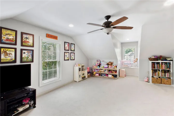 This spacious bonus room features soft carpeting and ample natural light from multiple windows.