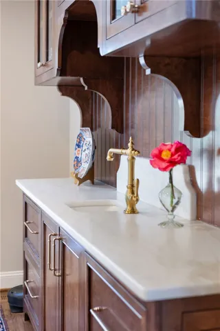 This elegant space showcases rich wood cabinetry, a polished countertop, and a classic faucet.