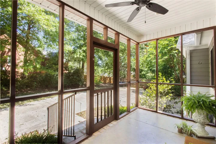 Enjoy outdoor living on this expansive screened porch, offering serene views and ample space for relaxation.
