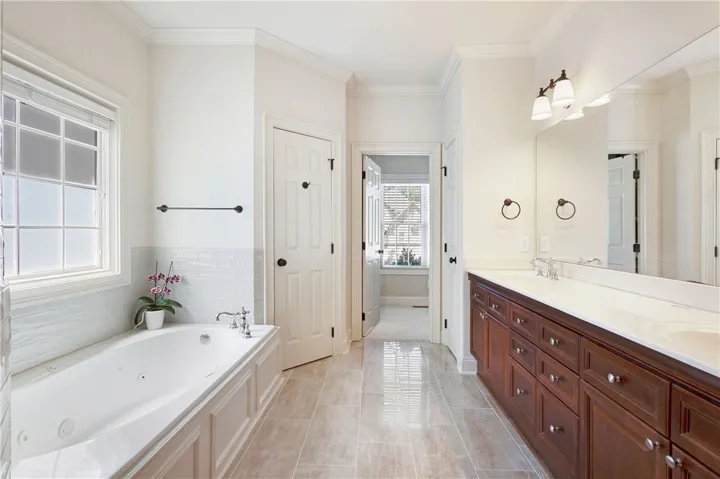This spacious bathroom offers a relaxing soaking tub and dual vanities for ultimate comfort.