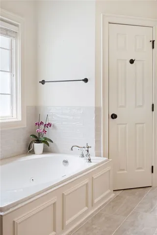 Relax and rejuvenate in this inviting bathroom featuring a deep soaking tub and elegant tile flooring.