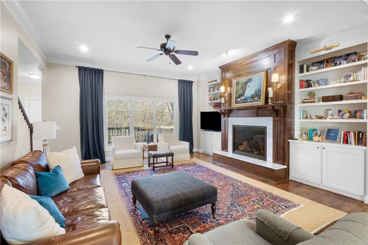 This inviting living room boasts warm hardwood floors and a cozy fireplace with elegant built-in shelving.