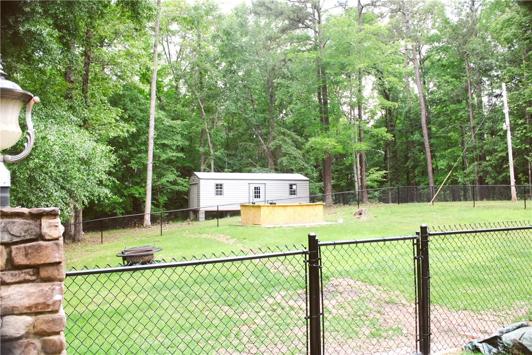 This spacious yard features a versatile outbuilding and a fenced perimeter for privacy.