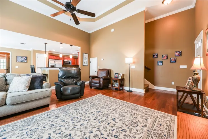This inviting great room features high ceilings and an open-concept flow to the adjacent kitchen.