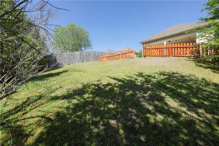 This spacious yard offers ample outdoor living potential, complete with fencing and a covered patio.