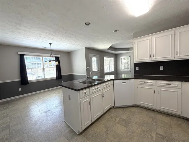 This kitchen and dining area features sleek countertops, ample cabinetry, and an open floorplan.