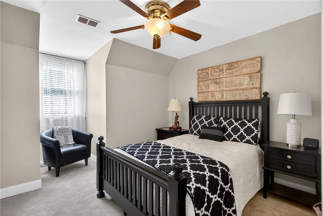 This cozy bedroom features comfortable carpeting and a bright window, creating a serene and inviting atmosphere.