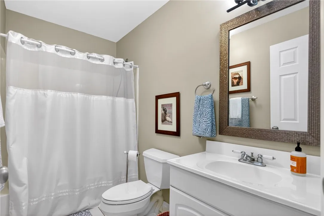 This bright bathroom features a spacious vanity and a combination shower-tub.