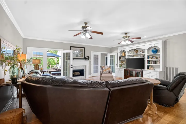 This inviting space features elegant built-in shelving, a cozy fireplace, and rich hardwood flooring, perfect for relaxation.