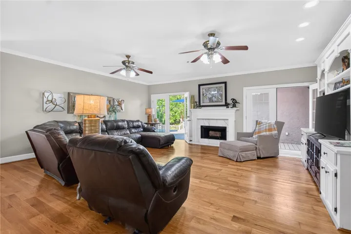 This inviting living room boasts warm hardwood flooring, a cozy fireplace, and ample natural light.