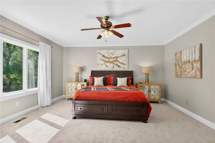 This spacious bedroom offers ample natural light and a serene atmosphere.