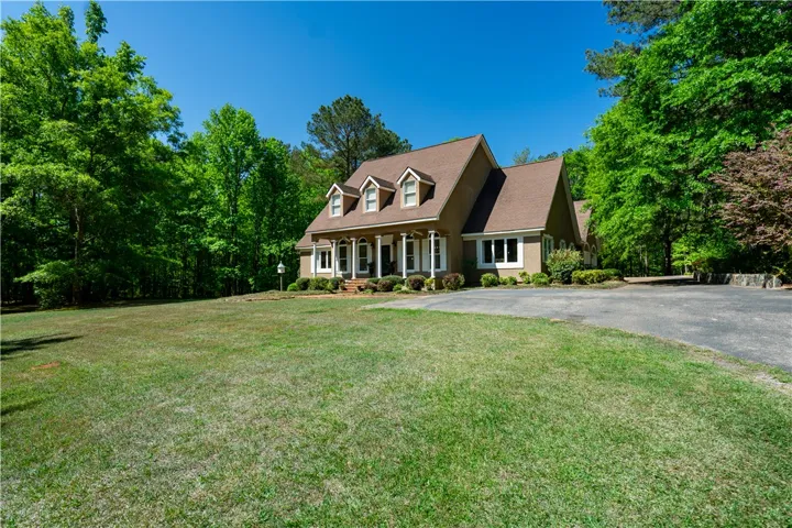 This secluded residence offers ample green space and a welcoming front porch set amidst mature trees.