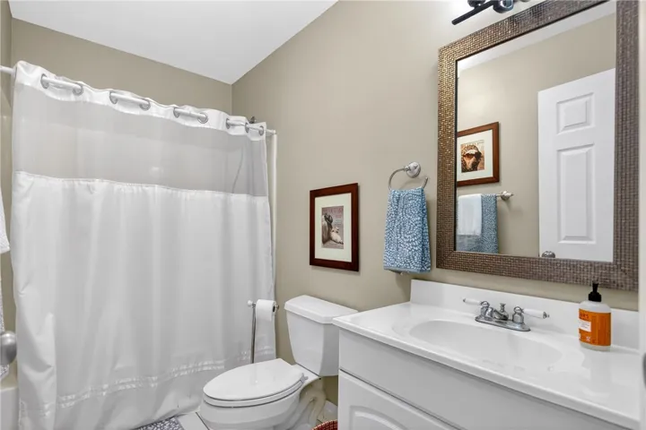 This bright bathroom features a spacious vanity and a combination shower-tub.
