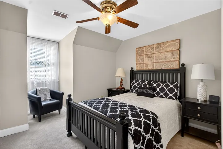 This cozy bedroom features comfortable carpeting and a bright window, creating a serene and inviting atmosphere.