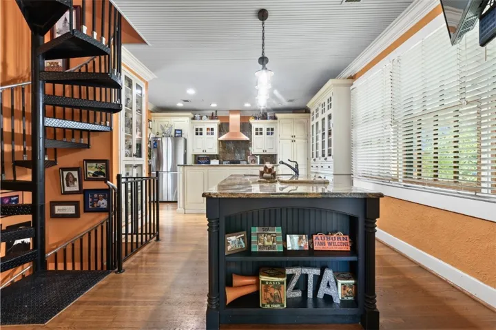 This kitchen and dining area features an inviting island, a spiral staircase, and wood flooring.