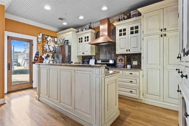 This updated spacious kitchen features ample cabinetry, gas stove and an island.