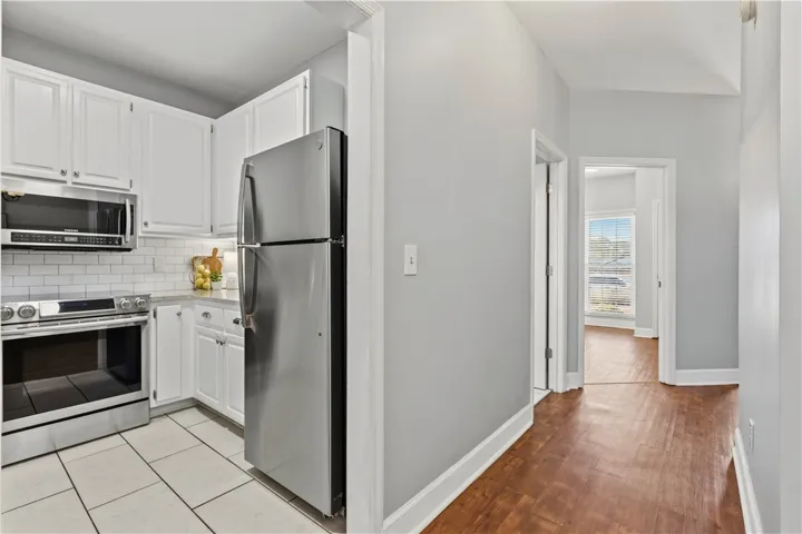 View towards front door & downstairs bedroom, then peeking into kitchen.
