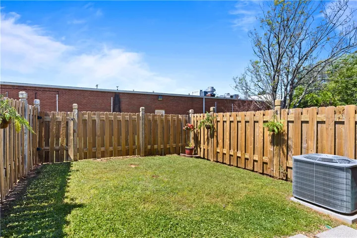 A well-kept yard enclosed by a robust wooden fence offers a private outdoor space.