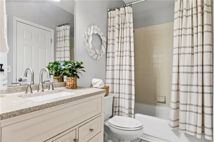 This ensuite or guest bathrm features a sleek vanity, modern fixtures, 12 x 24 floors and a shower with classic tile.
