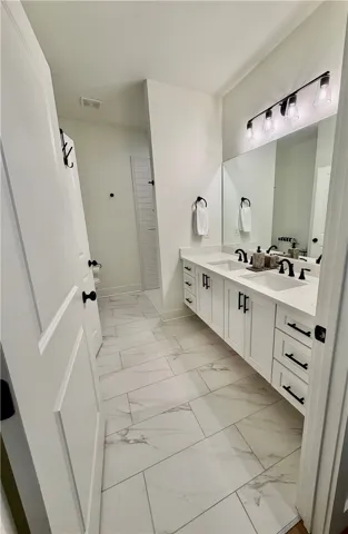 Excuse the wide angle view.  There was just too much to see...Double vanities, ample cabinets and dramatic fixtures.