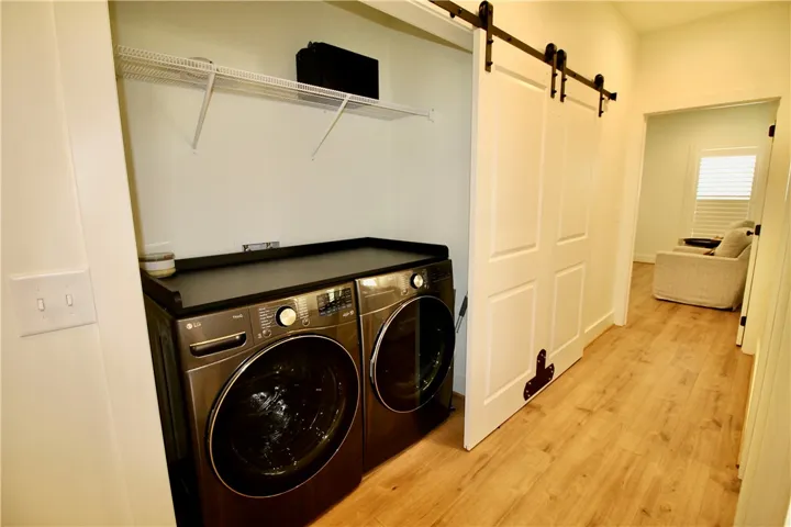 The washer and dryer remain.  Note the folding counter atop the units.  Plus, the shelving above for additional storage.  The sliding doors move with ease and offer a stylish look.