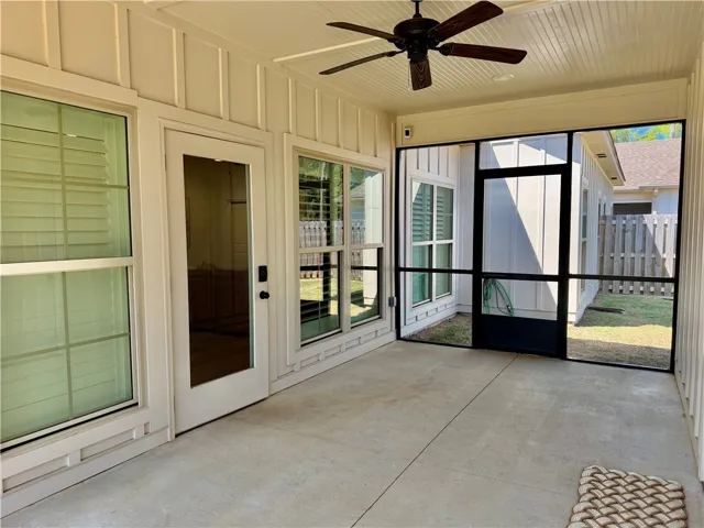 The screened porch has board and batten finishes, a ceiling fan and can lights.