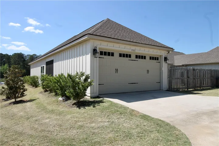 This view shows the garage and the fenced backyard.  Note the black screening of the screened porch.