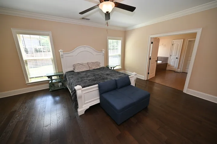 The primary bedroom finished with hardwood flooring and crown molding.