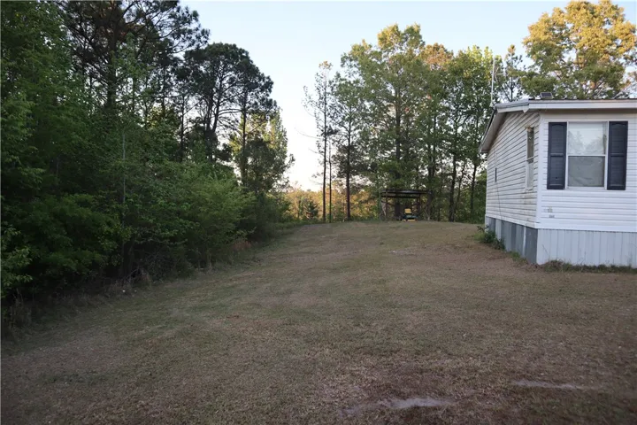 This tranquil setting offers a spacious yard beside a cozy dwelling.