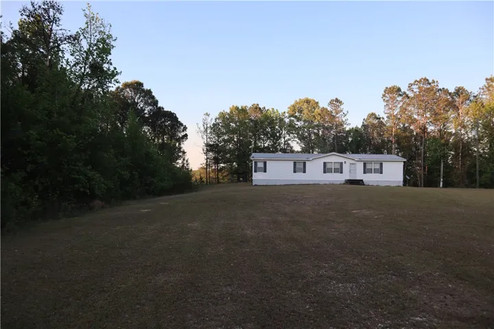 This tranquil rural property offers a spacious yard with mature trees.