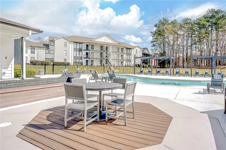 This inviting outdoor space offers a sparkling pool and comfortable seating for relaxation and enjoyment.