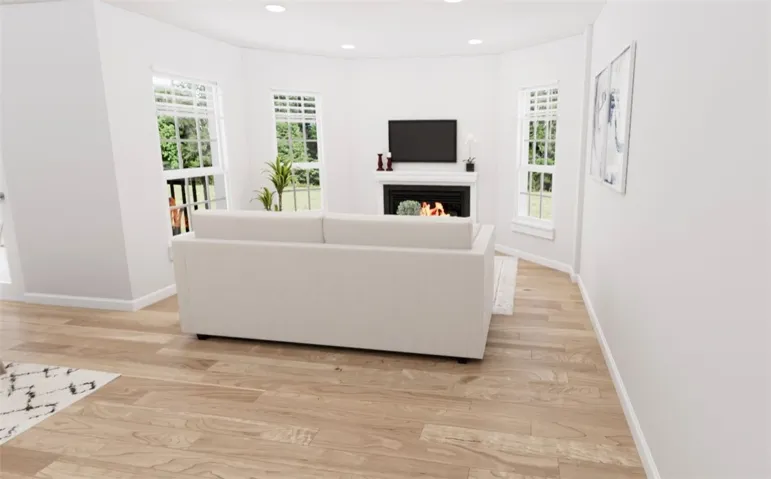 This bright living space features elegant hardwood flooring and a cozy fireplace.