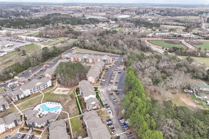 An aerial view showcases a vibrant community with ample parking and inviting recreational spaces.