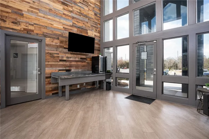 This spacious entry features large windows and a unique wooden accent wall, creating a welcoming and modern ambiance.