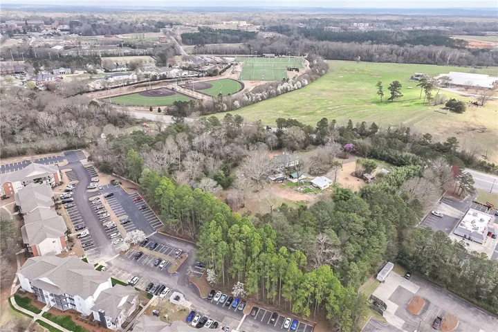 This elevated view captures the extensive property with adjacent recreational fields and verdant surroundings.