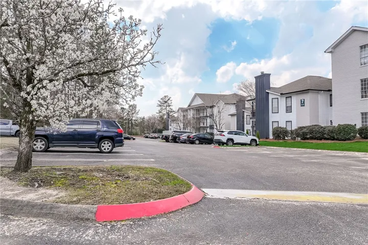 This residential building is set amidst a lush landscape, offering ample parking and a serene environment.