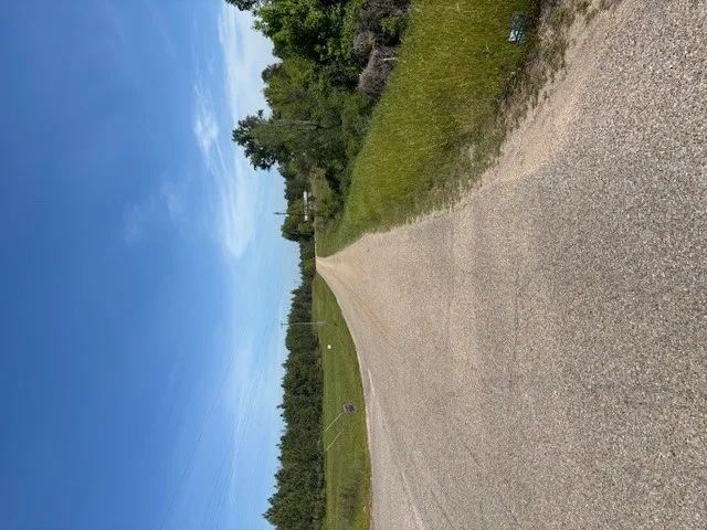 A long, winding gravel driveway leads to your secluded home, surrounded by lush greenery.