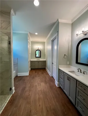 This primary bathroom features a long layout with dual vanities and modern fixtures.